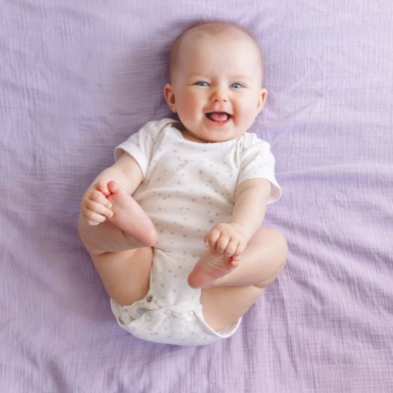Kinderwunsch Coaching - Ein Herzensthema - lachendes Baby auf lila Decke